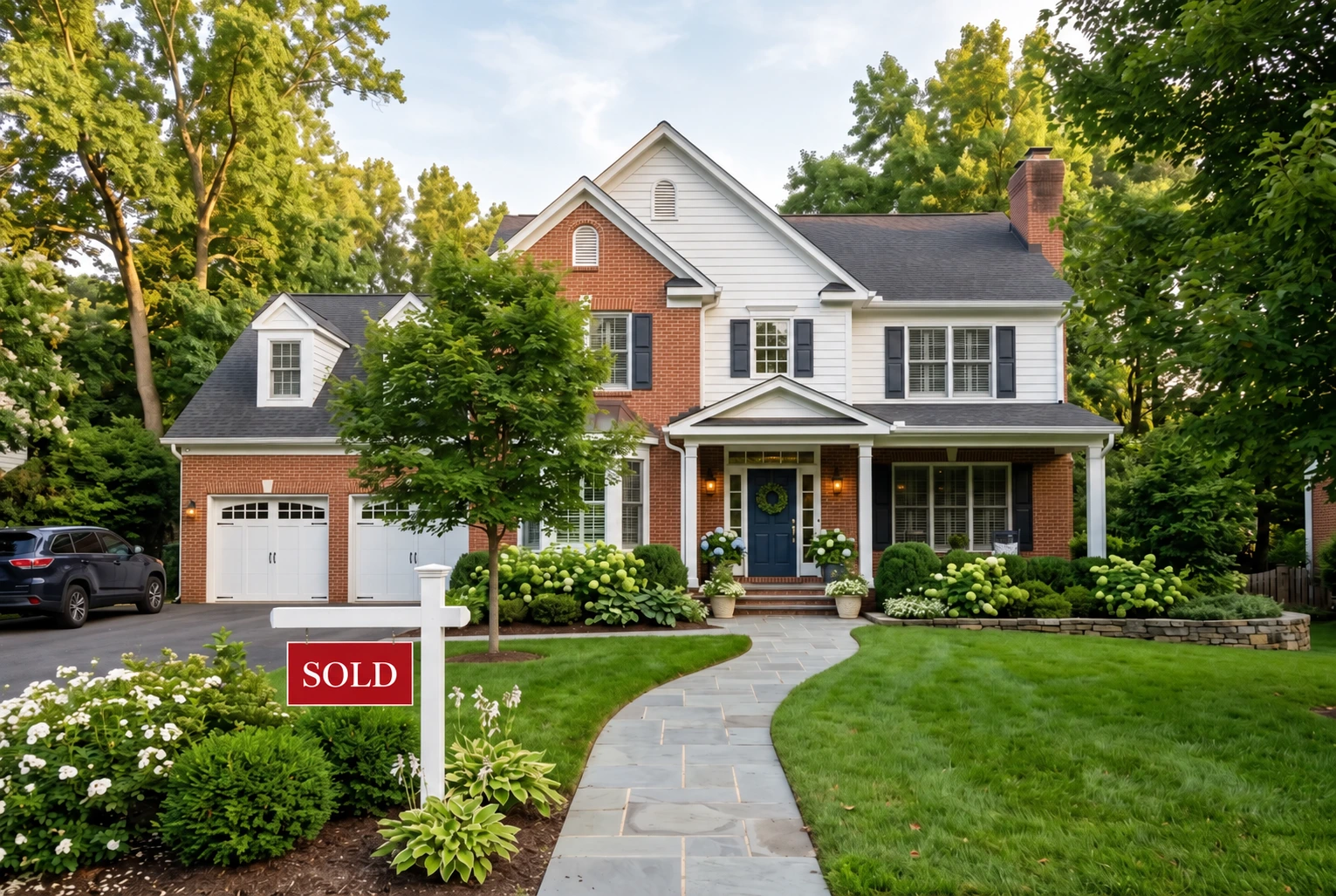 An inviting home with a red sold sign and a beautifully landscaped entrance
